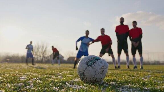 冬天的一天一名足球运动员在足球场上踢任意球