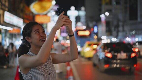 年轻的女游客喜欢在晚上走在曼谷的街道上穿过曼谷唐人街的著名街道