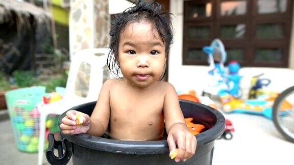 亚洲小女孩在黑色浴缸里洗澡