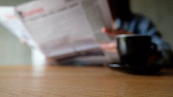 模糊地看到一个女人在看报纸咖啡杯放在桌子上