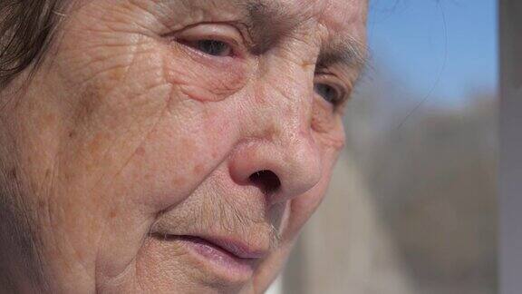 一个老太婆的悲伤的脸的特写从颤抖颤抖的眼皮