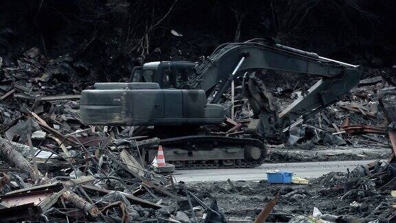 日本福岛2011年3月11日:海啸过后一台挖土机在日本被毁房屋的废墟之间穿行