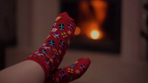 圣诞节时穿着温暖羊毛袜子的女人躺在壁炉旁圣诞节的背景