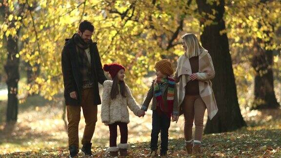 快乐的一家人在秋天散步在公园里