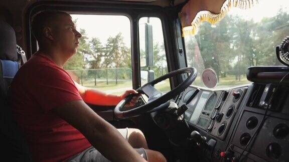 在乡村公路上卡车司机手握方向盘驾驶汽车在手动变速器和控制卡车上换挡的人卡车司机正驶向目的地物流