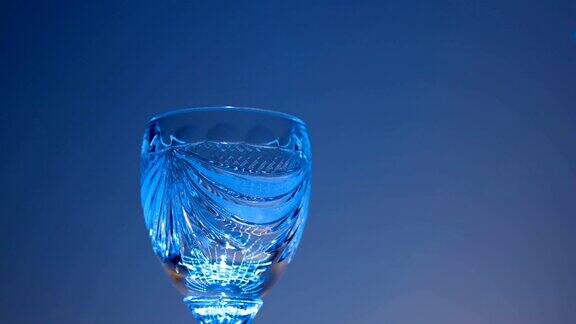 在移动的光线下将红葡萄酒从玻璃瓶倒入酒杯