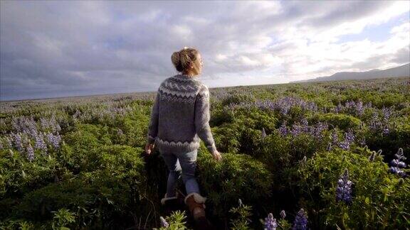 慢动作视频快乐的女人走在花的田野在日落享受自由的自然旅行无忧无虑的生活在最充分的慢动作视频