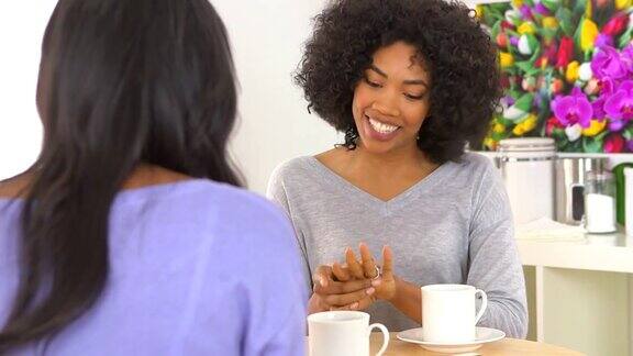 一位非洲裔美国妇女向朋友展示订婚戒指