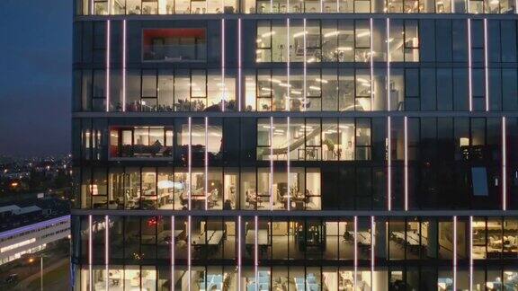 俯瞰现代摩天大楼办公室的夜景商人们工作到很晚