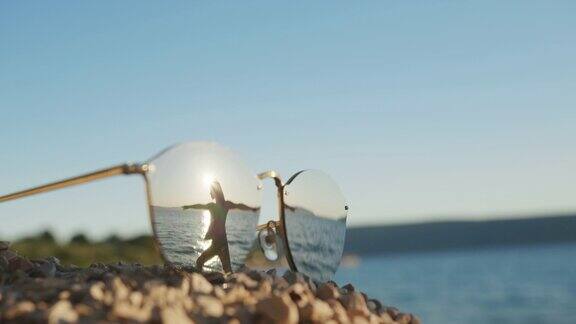 在海滩上锻炼的女人的太阳镜反射