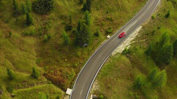 红色汽车行驶在弯弯曲曲的道路上蜿蜒在山坡上