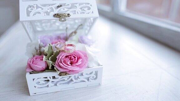 给新娘和新郎的漂亮的结婚戒指和鲜花