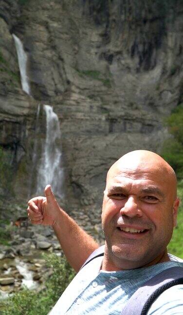 一名男子拍了一张以瀑布为背景的自拍视频
