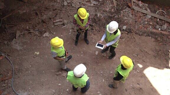 建筑承建商在建筑工地与土木工程师会面时展示数码平板电脑