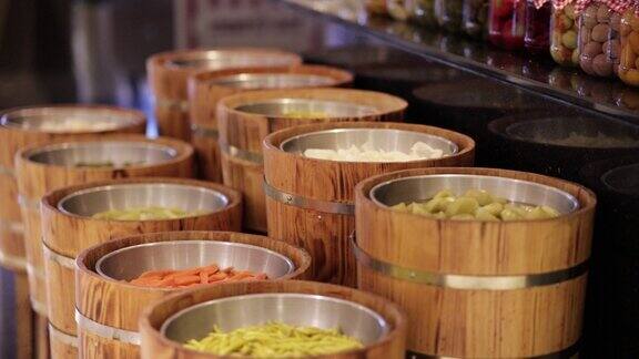 各种各样的玻璃罐装满了腌菜家庭罐头保存腌制食品储存在木制存储架腌菜罐