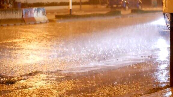 热带降雨在夜间的道路在亚洲汽车在大雨下站立和行驶泰国