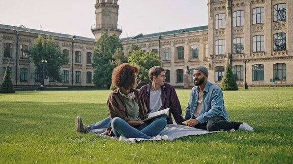 一群跨国学生坐在草地上聊天