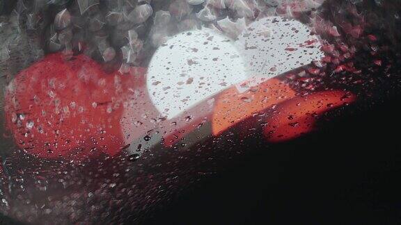 雨滴落在车窗上汽车交通散焦灯在黑暗的夜晚背景悲伤和悲伤的情绪背景