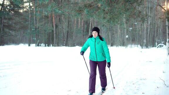 活跃的女人在森林里越野滑雪