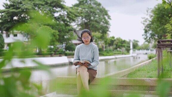 一个亚洲女人在公园里看书