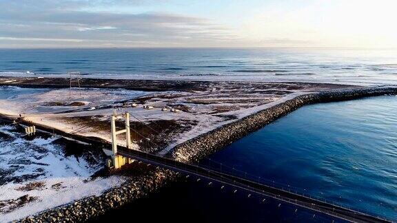 俯瞰冰岛的一座桥这座桥靠近大海、冰川和冰山在夕阳的照耀下大地上有雪白的冰雪