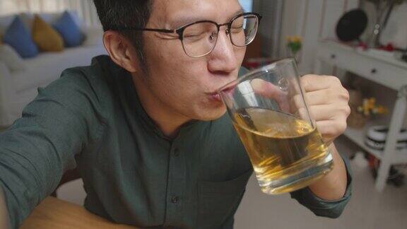 POV屏幕手机:迷人的年轻快乐的亚洲男人享受放松的夜晚派对活动在线庆祝节日与朋友在家里用玻璃杯和瓶子碰杯干杯通过视频电话喝酒