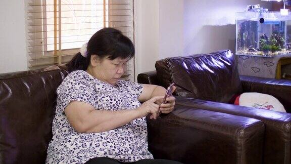 使用智能手机的亚洲老年妇女
