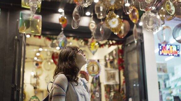 墨西哥普拉亚德尔卡门一名妇女正在挑选挂在纪念品商店里的风轮