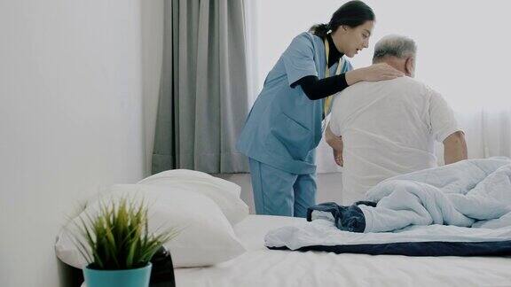 图为护士帮助老人起床