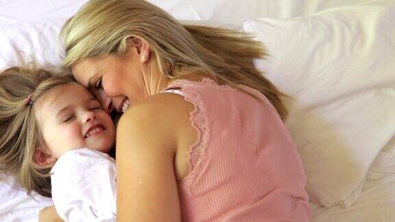 母亲和女儿在床上拥抱