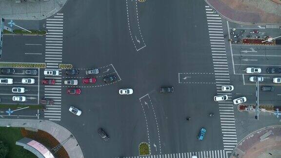 无人机拍摄的城市十字路口汽车和公交车行驶在大道上在日落时分相机移动