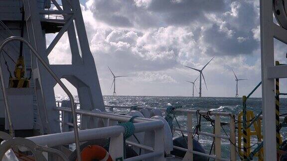 从转轮(船轮渡)甲板上看航行在暴风雨天气的北海风力发电场周围水平方向上的风力涡轮机戏剧性的天空皇家空军的大海和阳光德国博库姆里夫grund风电场