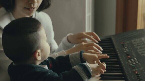 一位中国母亲教她的儿子弹钢琴