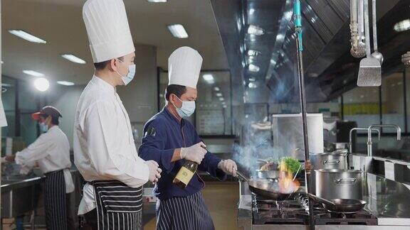 在酒店餐厅厨房里准备食物的厨师团队食物和丁克概念