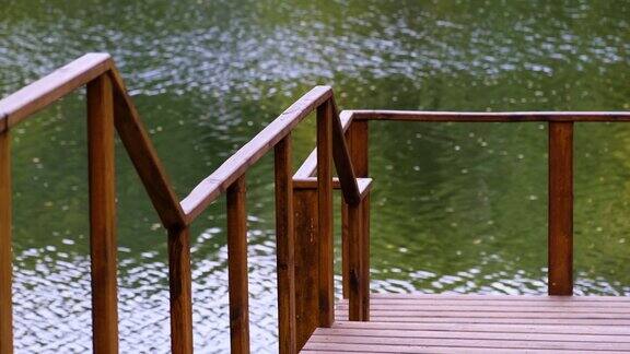 木制的空码头与栏杆在流动的河流背景在美丽平静的夏日宁静