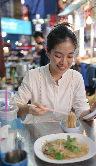 诱人的旅游亚洲饮食-坐在路边吃炒米粉鱼妈和螃蟹街头小吃在泰国曼谷的唐人街耀华叻