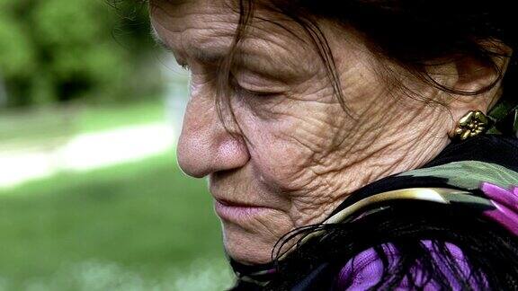 一个忧愁沮丧的老妇人独自坐着:悲伤的女人孤独的女人