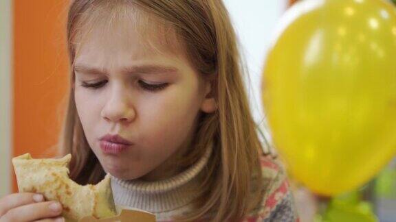 一个小女孩在咖啡馆里吃煎饼传统的俄罗斯快餐