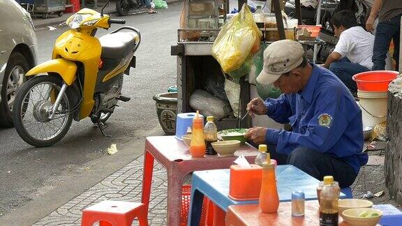 胡志明西贡越南2015年:一个人在街上吃东西