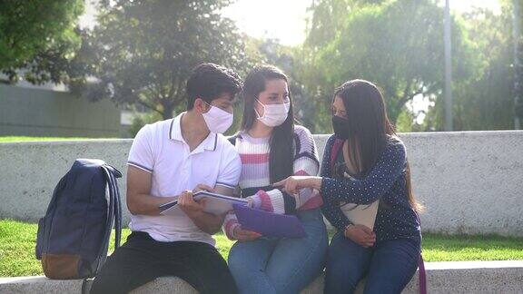 一群朋友在大学校园里一起学习一起玩都戴着防护口罩