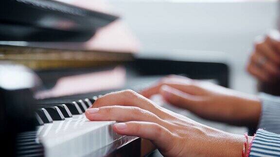 音乐课上学生与老师弹钢琴的特写