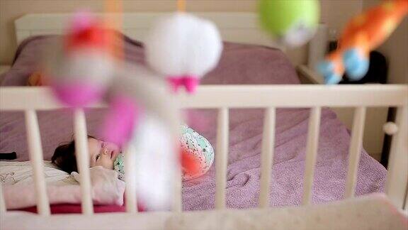 婴儿躺在床上看玩具