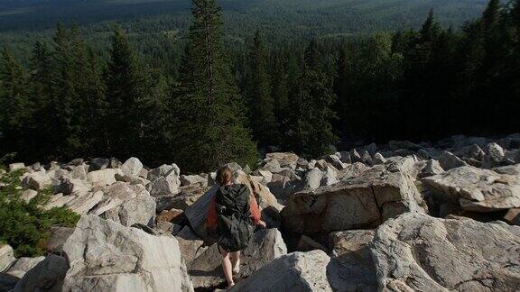 一个年轻的女人有一个冒险-去下山的背包在她的背上