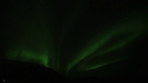 北极光在夜空中群山上空的剪影一次圈