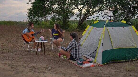女人们在夏令营里唱歌和弹吉他
