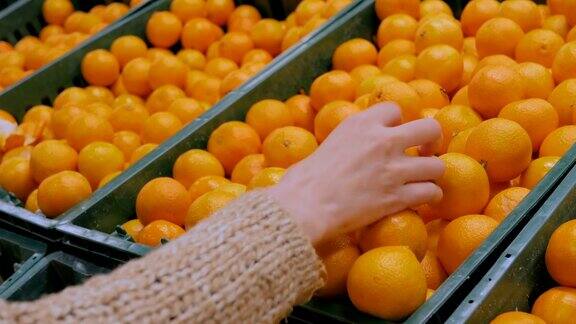 在杂货店买新鲜橘子的女人