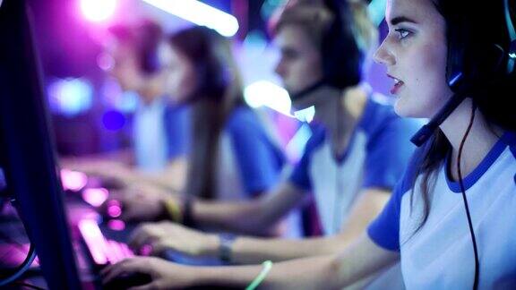 在一场网络游戏锦标赛上玩竞技电子游戏的职业电竞玩家团队他们对着麦克风交谈