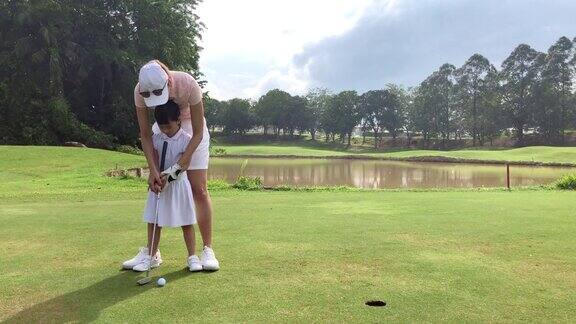 亚洲华人年轻母亲高尔夫球教她的女儿打高尔夫球场
