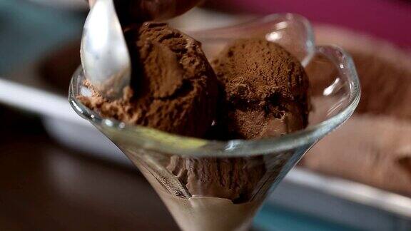 从容器中舀咖啡冰淇淋把球放到前面的玻璃碗中