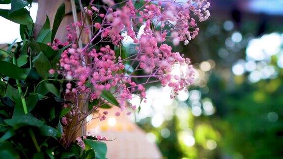 闪闪发光的婚礼装饰粉红色的花朵和阳光镜头光晕
